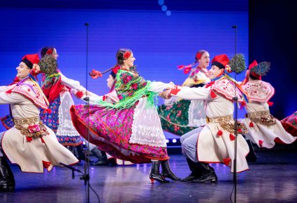 Pary Artystów w kostiumach krakowskich w trakcie wykonywania imponującej choreografii tanecznej
