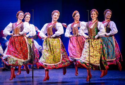 Zbliżenie na Artystki w kostiumach krakowskich wykonujące choreografię taneczną