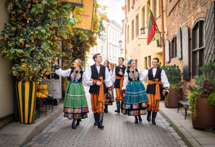 Trzy pary Artystów w kostiumach łowickich podczas spaceru przez malownicze uliczki Wilna