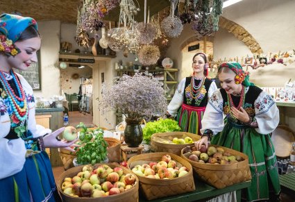 Artystki w kostiumach łowickich w otoczeniu warzyw i owoców w Wileńskim warzywniaku