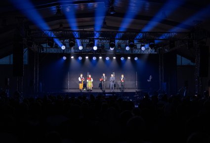 Na scenie Artystka i Artysta Chóru w kostiumach łowickich wraz z władzami miasta Glinojeck podczas wspólnego czytania "Dziadów" A. Mickiewicza