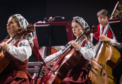 Artyści Orkiestry w kostiumach wilanowskich w trakcie grania na instrumentach smyczkowych