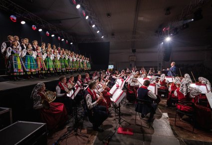 Widok z bocznej perspektywy na Artystów Orkiestry w kostiumach wilanowskich oraz Artystów Chóru w kostiumach łowickich