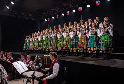 Na scenie Artyści Chóru w kostiumach łowickich, niżej Artyści Orkiestry w kostiumach wilanowskich