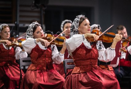 Zbliżenie na Artystki Orkiestry w kostiumach wilanowskich, grające na instrumentach smyczkowych