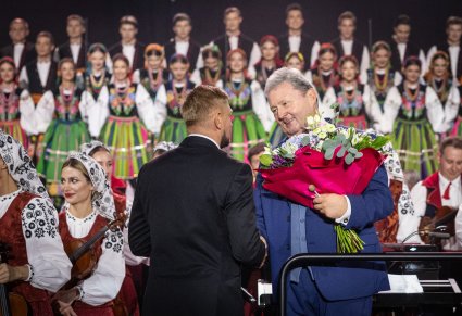Zbliżenie na Burmistrza miasta i Dyrektora w momencie wręczania kwiatów