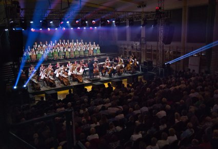 Publiczność, na scenie Artyści Chóru w kostiumach łowickich, Orkiestra w kostiumach wilanowskich oraz Dyrygent