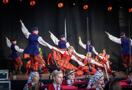 Tancerze baletu w kostiumach sieradzkich, podczas tańców sieradzkich, poniżej część orkiestry w kostiumach wilanowskichch