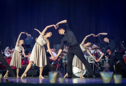 Na scenie Artyści Baletu w kostiumach współczesnych podczas wykonywania choreografii tanecznej