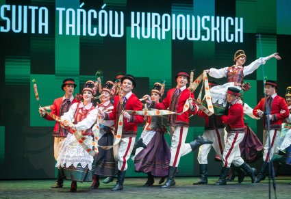Grupa taneczna w kostiumach kurpiowskich wykonująca układ taneczny