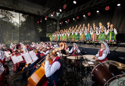 Cały Chór w kostiumach łowickich, widoczna także część orkiestry w kostiumach wilanowskich.