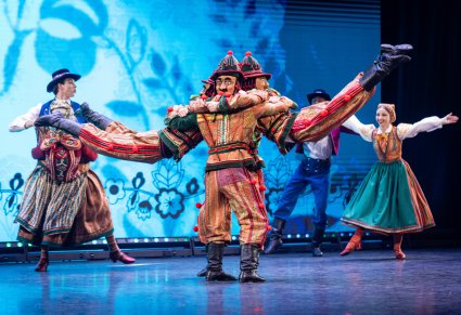 Na pierwszym planie wilamowickie pajace w trakcie wykonywania choreografii tanecznej, w tle Artyści wraz z wilamowicką Babą