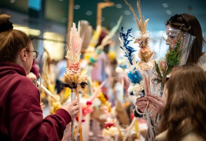 Zbliżenie na gości przy palmach na XIII Jarmarku Wielkanocnego w Karolinie