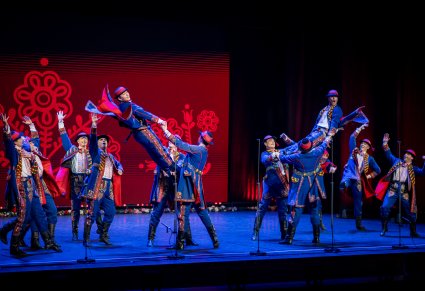 Tancerze w kostiumach podegrodzkich podczas akrobacji tanecznych na scenie