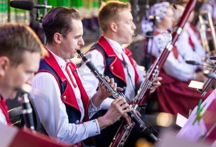 Zbliżenie na Artystów Orkiestry w kostiumach wilanowskich podczas grania na instrumentach dętych