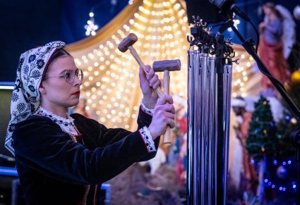 Zbliżenie na artystkę orkiestry grającą na dzwonkach