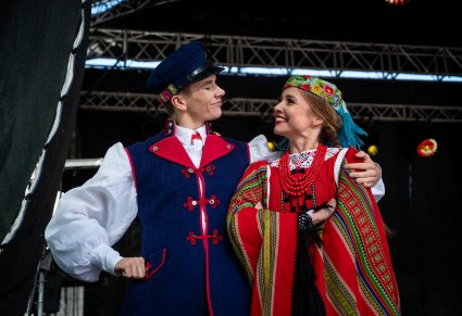 Uśmiechnięta para Artystów w kostiumach sieradzkich na scenie