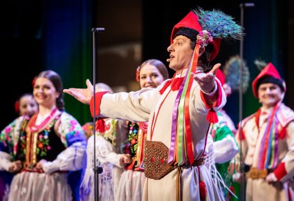 Zbliżenie na śpiewającego artystę w kostiumie krakowskim podczas koncertu