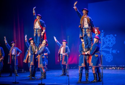 Tancerze w kostiumach podegrodzkich wykonujący akrobacje na scenie