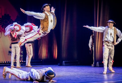 Tancerze w kostiumach jurgowskich podczas akrobacji tanecznych na scenie