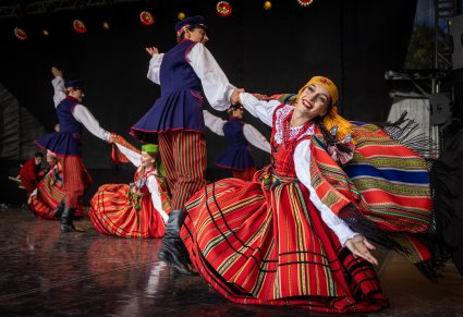 Trzy pary Artystów w kostiumach sieradzkich wykonujące choreografię taneczną na scenie