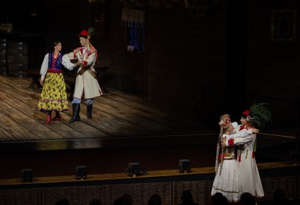 Na scenie Solista wraz z tancerką w kostiumach krakowskich, poniżej sceny Para Młoda