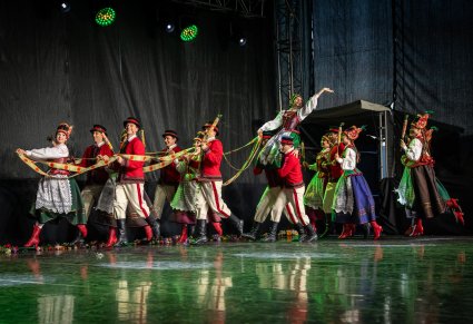 Tancerze w kostiumach kurpiowskich wchodzący na scenę