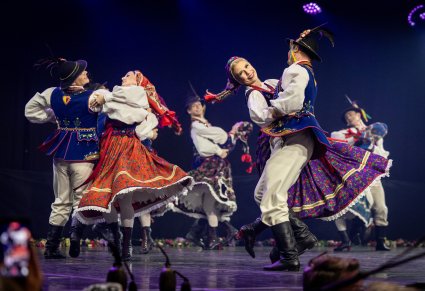 Zbliżenie na pary Artystów w kostiumach limanowskich w trakcie wykonywania choreografii tanecznej