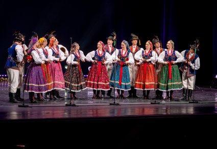 Na scenie Artyści w kostiumach limanowskich podczas grania na instrumentach regionalnych