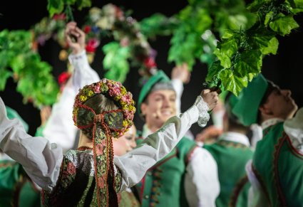 Zbliżenie na detale kostiumu lubuskiego kobiecego, grupa Artystów w kostiumach lubuskich w trakcie wykonywania choreografii tanecznej