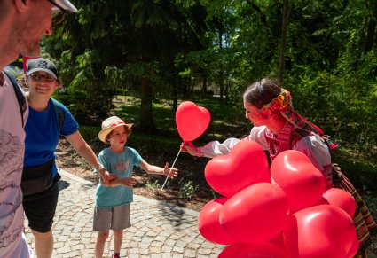 Artystka w kostiumie krzczonowskim w trakcie rozdawania balonów dzieciom na Pikniki Rodzinnym