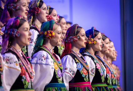 Zbliżenie na Artystki Chóru w kostiumach łowickich podczas śpiewu
