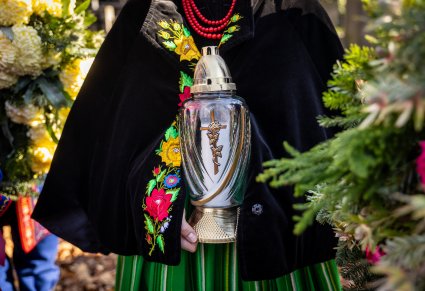 Zbliżenie na znicz w dłoniach Artystki w kostiumie kocierzewskim