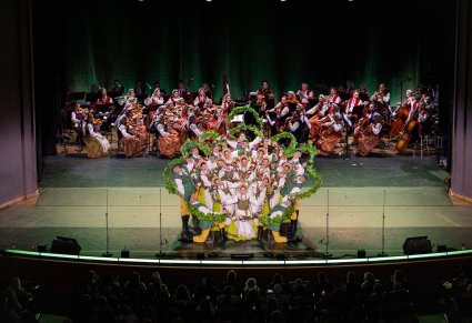 Widok na całą scenę, na scenie Artyści w kostiumach lubuskich w trakcie wykonywania finałowego momentu choreografii tanecznej. Z tyłu sceny widoczna Orkiestra w kostiumach wilanowskich