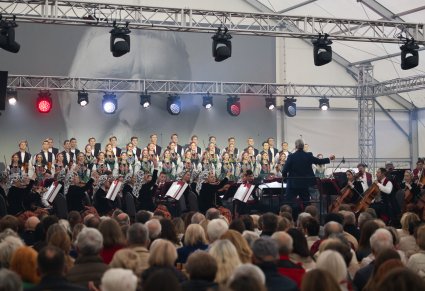 Widok na scenę ze wszystkimi artystami, poniżej widoczny fragment publiczności od tyłu
