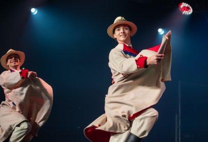 Dwóch Artystów w kostiumach łańcuckich w trakcie wykonywania choreografii tanecznej na scenie