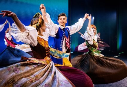 Trójka Artystów w kostiumach rozbarskich w trakcie wykonywania choreografii tanecznej