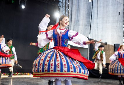 Na pierwszym planie Artystka Baletu w kostiumie spiskim podczas wykonywania obrotów, za nią jej partner również w kostiumie spiskim