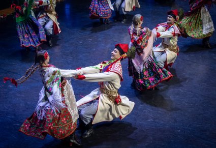 Zbliżenie na pary taneczne w kostiumach krakowskich podczas obrotów na scenie
