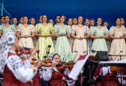 Zbliżenie na Artystów Chóru w kostiumach stylowych z końca XIX wieku, widoczna część Orkiestry w kostiumach wilanowskich