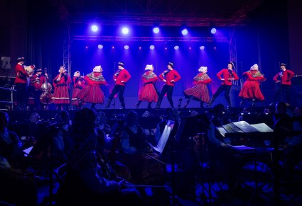 Orkiestra, w tle widoczna scena i artyści w kostiumach lubuskich