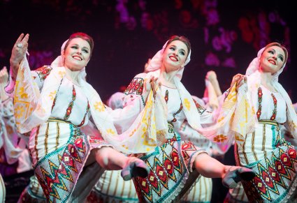 Zbliżenie na tancerki baletu Mołdawii w tradycyjnych kostiumach w figurze tanecznej