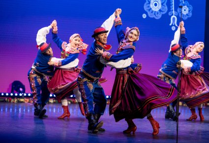 Pary Artystów w kostiumach podegrodzkich w trakcie wykonywania choreografii tanecznej