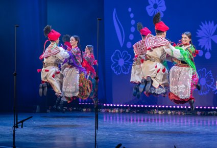 Artyści w kostiumach krakowskich podczas układu tanecznego na scenie