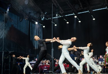 Na scenie Artyści Baletu w kostiumach współczesnych podczas wykonywania choreografii tanecznej