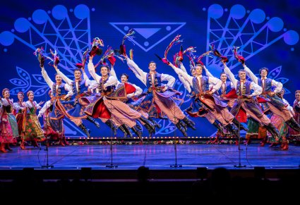 Tancerze w kostiumach krakowskich na scenie w figurze tanecznej