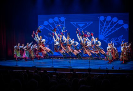 Tancerze w kostiumach krakowskich wykonujący akrobacje taneczne na scenie