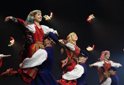 Trzy pary Artystów w kostiumach sieradzkich w trakcie wykonywania choreografii tanecznej