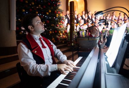 Zbliżenie na grającego akompaniatora w kostiumie łowickim