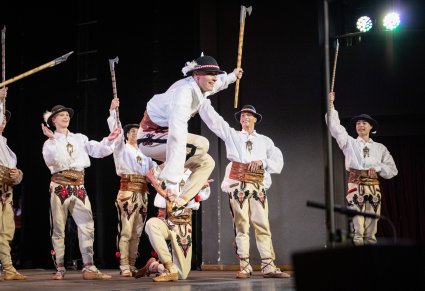 Zbliżenie na Artystów Baletów w kostiumach podhalańskich w trakcie wykonywania choreografii tanecznej